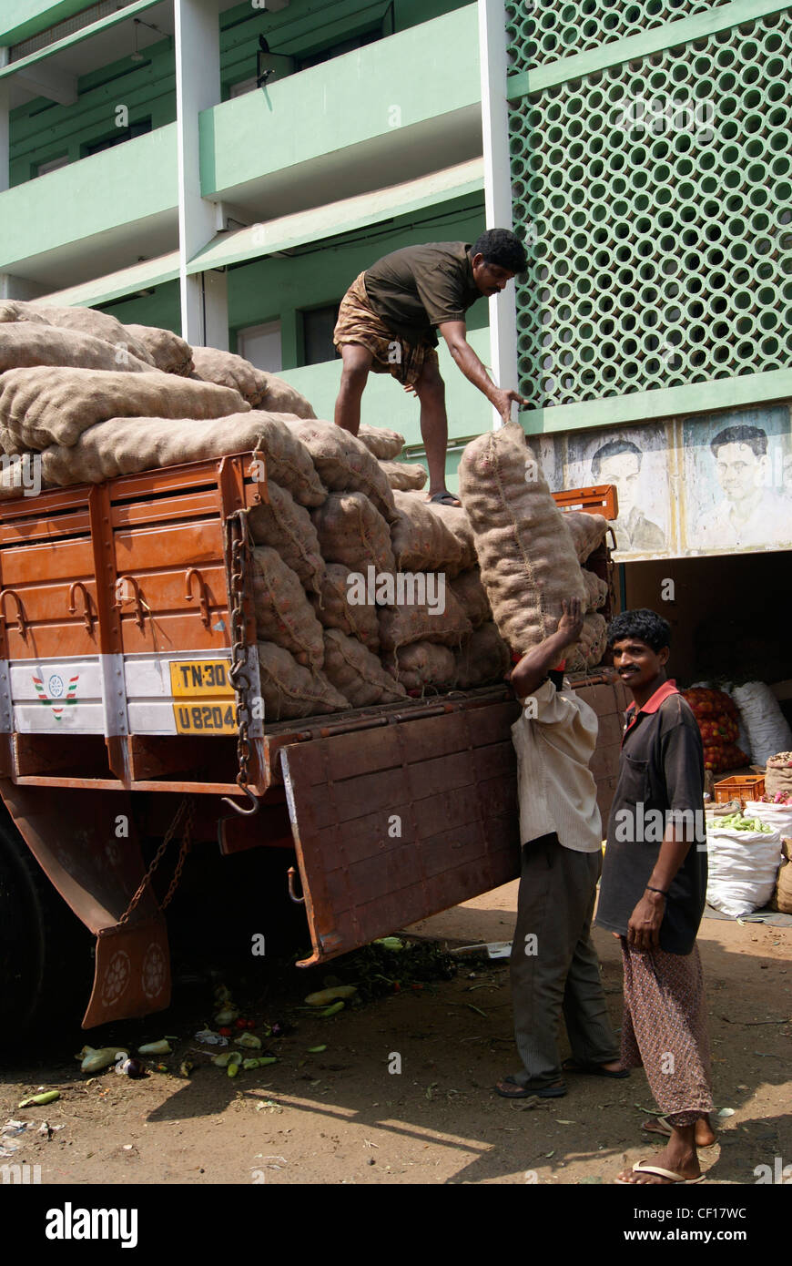 Loading workers Unloading Big Onion sacks Importing from Tamil Nadu Lorry to the godown of Chalai bazaar Thiruvananthapuram Kerala India Stock Photo
