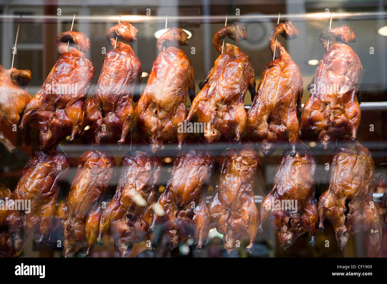 Crispy roast duck on spits in a chinese restaurant shop window