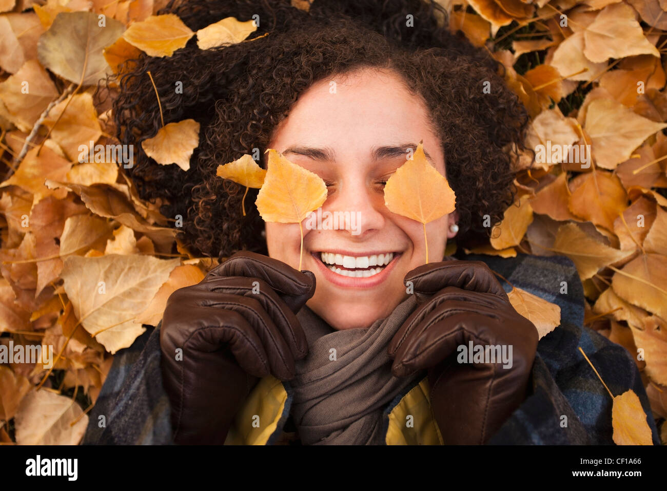 Caucasian woman laying in autumn leaves Stock Photo - Alamy