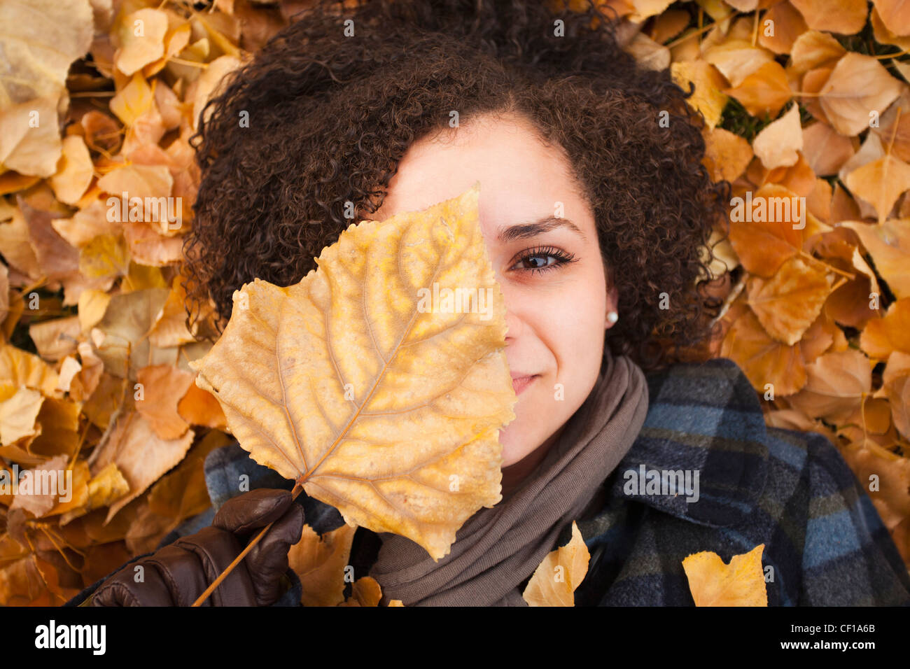 Caucasian woman laying in autumn leaves Stock Photo - Alamy