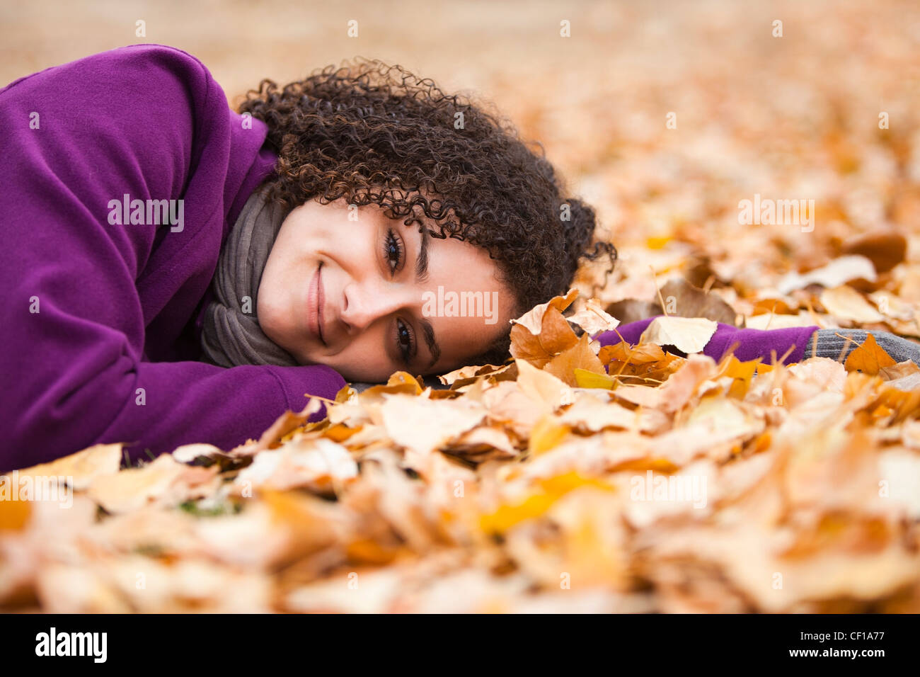 Caucasian woman laying in autumn leaves Stock Photo - Alamy