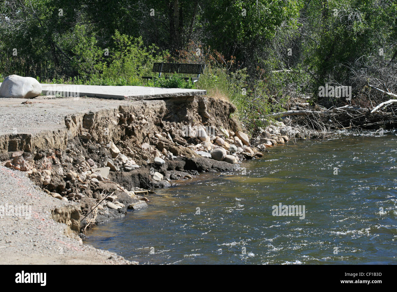 an eroded sidewalk washed away by a flooded river Stock Photo