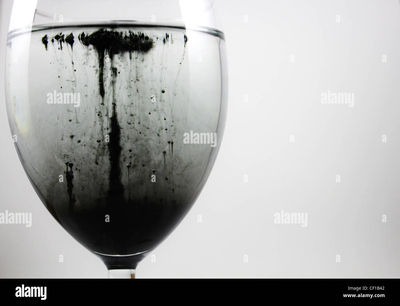 Black liquid flowing in a wine glass Stock Photo Alamy