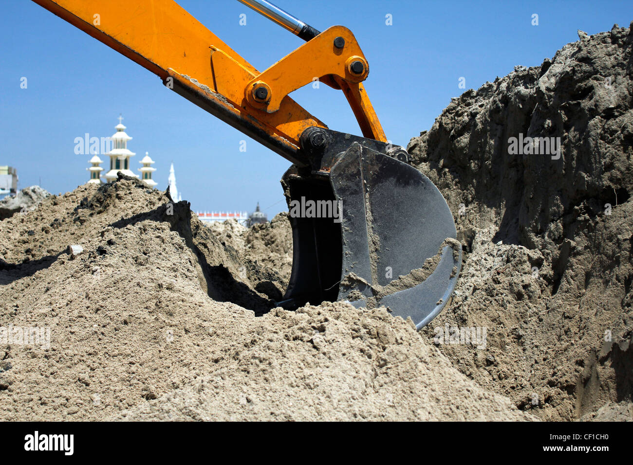 An arm of a JCB, earth mover digging into sand Stock Photo - Alamy