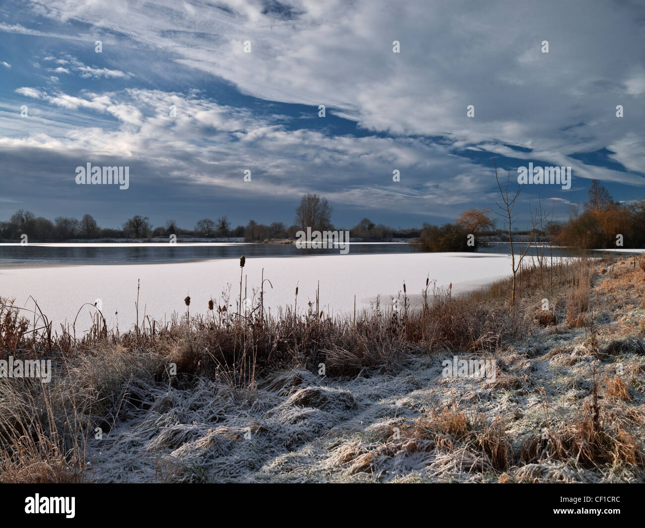 Snow covering Mallard Lake, one of three lakes in the Lower Moor Farm Nature Reserve, designated a Site of Special Scientific In Stock Photo