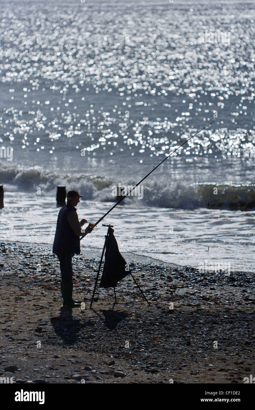 An angler fishing from the beach at Tywyn, a seaside resort on Cardigan Bay. Stock Photo