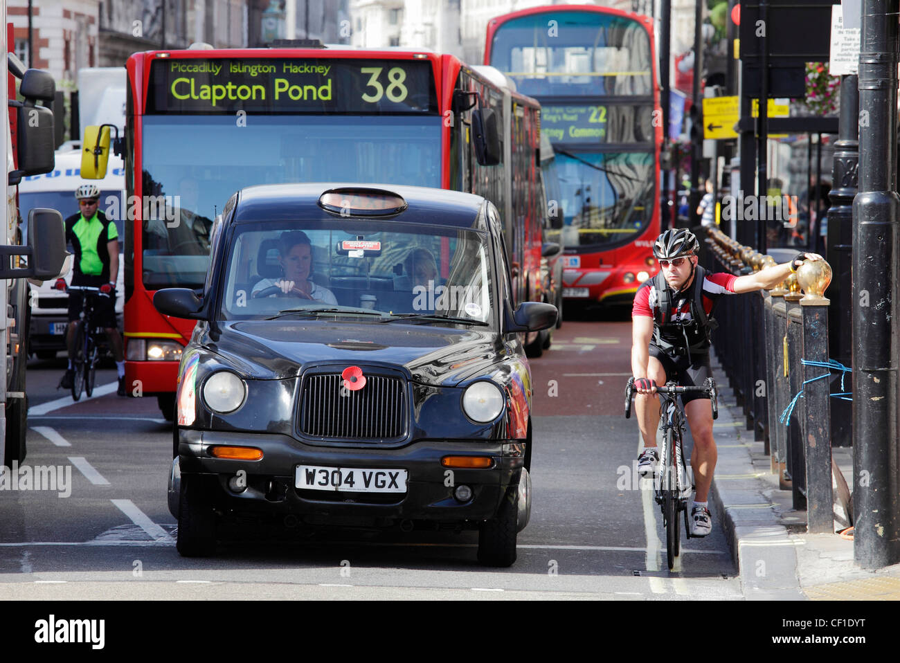 Cyclists, busses and taxis waiting at traffic lights in Piccadilly. Stock Photo