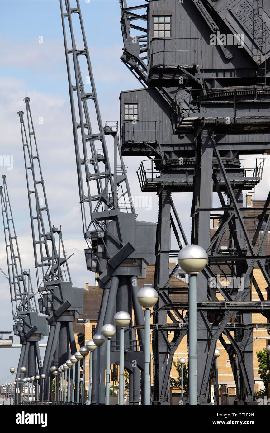 Derelict cranes stand as a reminder of the past at Royal Victoria Dock in the redeveloped Docklands area of London. Stock Photo