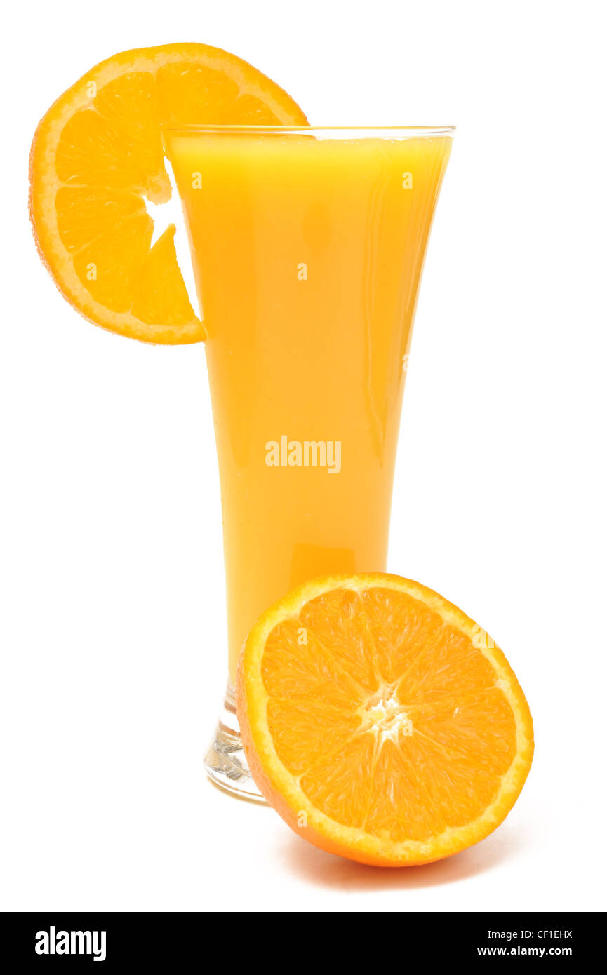 Photograph of orange juice in a glass with half an orange and a slice