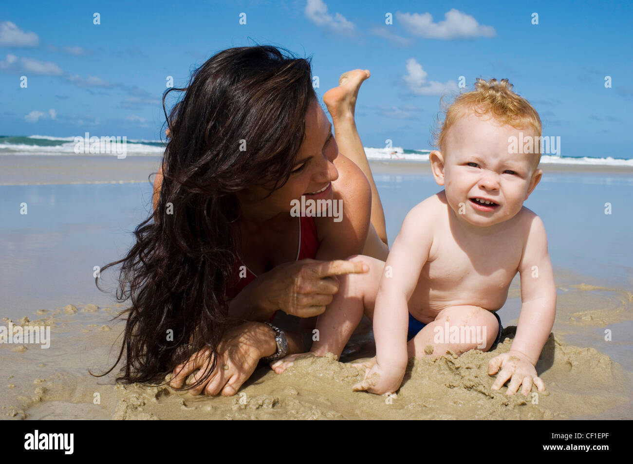 Female Long Brunette Hair Wearing Red Bikini Lying On Sandy