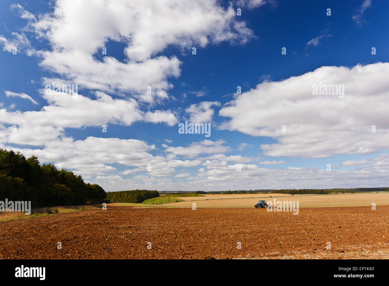 Tractor ploughing a large field in the countryside near Cirencester. Stock Photo