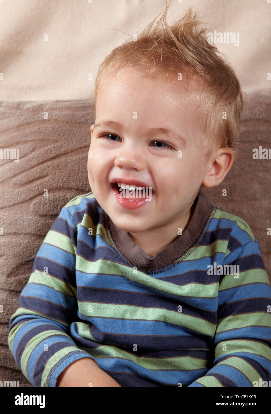 Portrait of a little baby boy laughing outloud. Indoor shot. Stock Photo