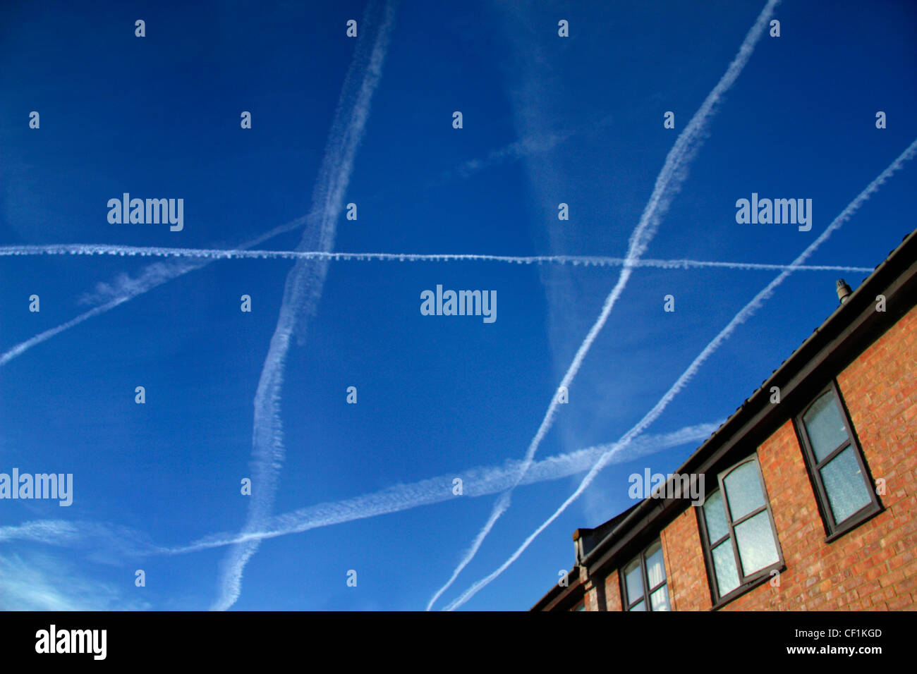 Late summer afternoon sky full of contrails. Stock Photo