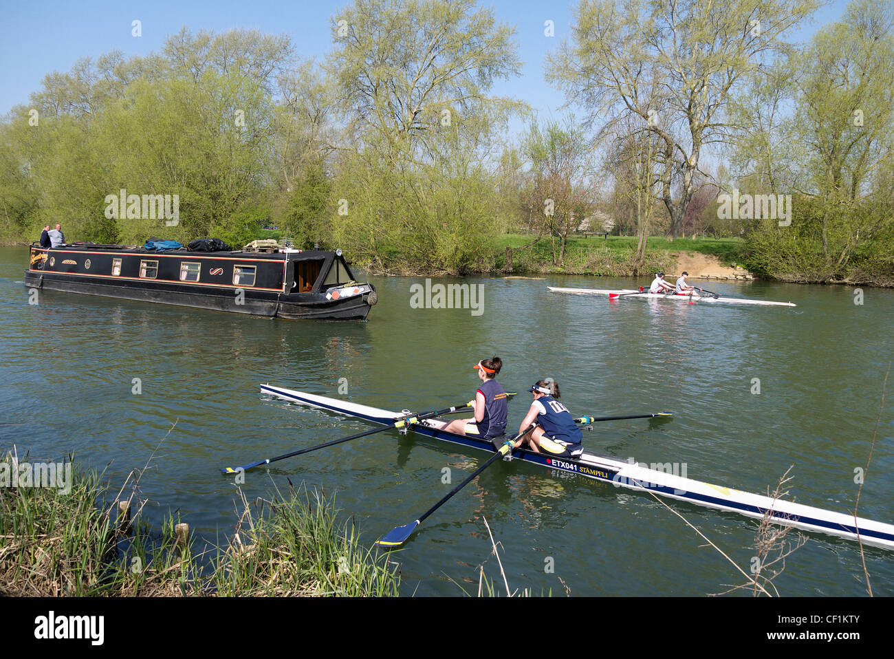 Two double sculls and a barge on the River Thames at Abingdon. Stock Photo