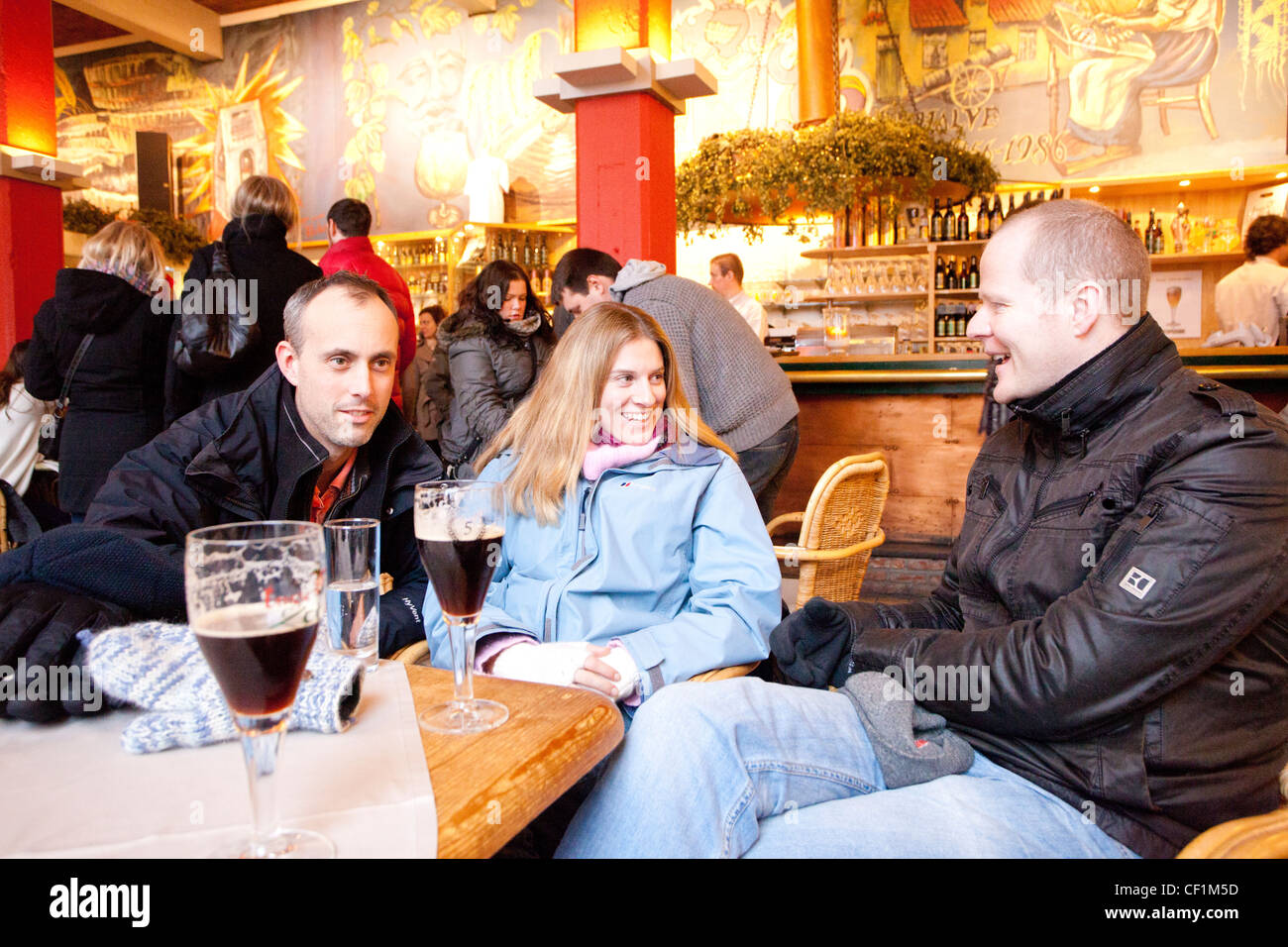 A group of tourists sitting around a table talking in the Zot Brewery bar in Bruges Stock Photo