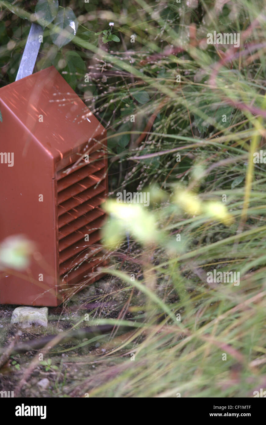 Creating wildlife habitats A ladybird nesting box next to an area of long unmown grass Stock Photo
