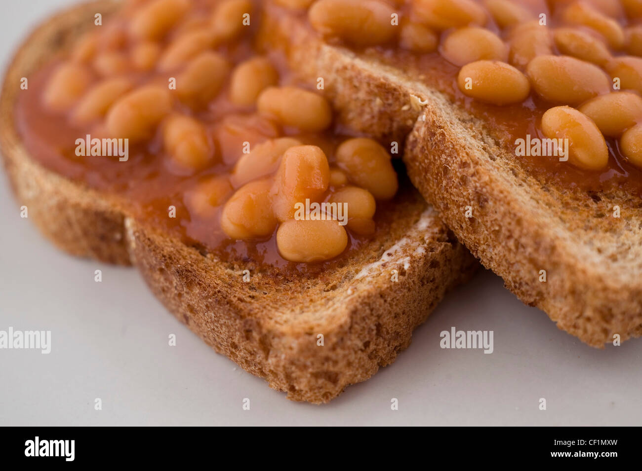Two slices of toasted bread with baked beans on white plate Stock Photo
