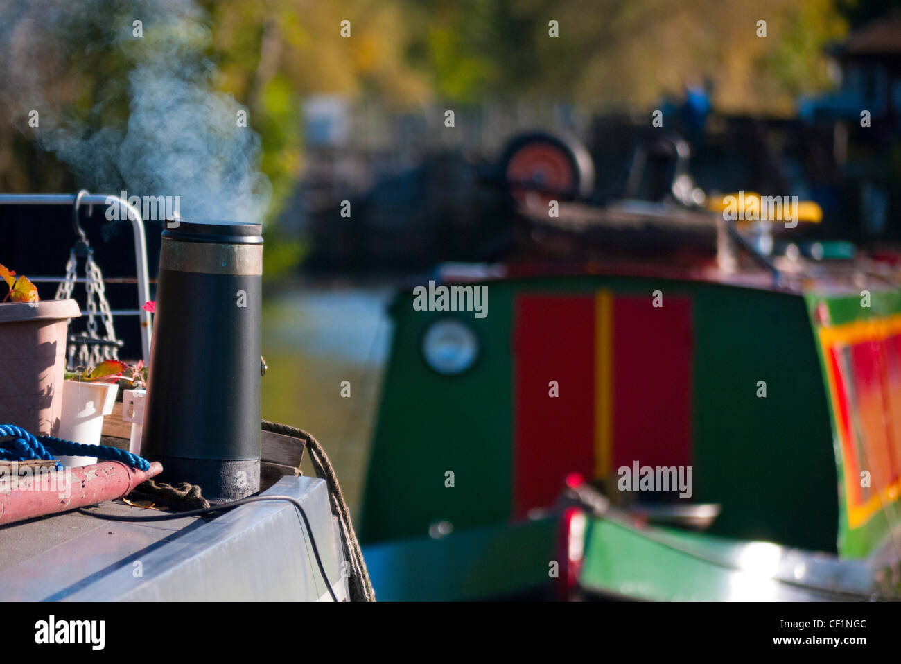 Smoking chimney on a houseboat moored on the River Thames. Stock Photo
