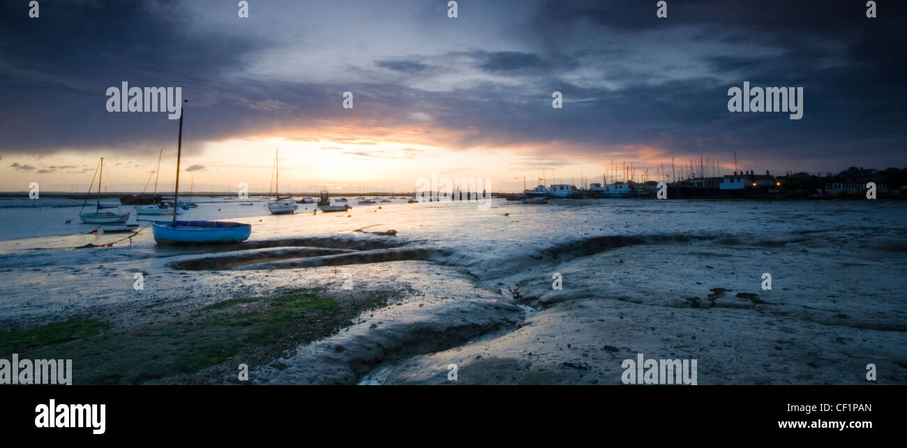 Boats at low tide in West Mersea. It is located on Mersea Island which is the most easterly inhabited island in the UK. Stock Photo