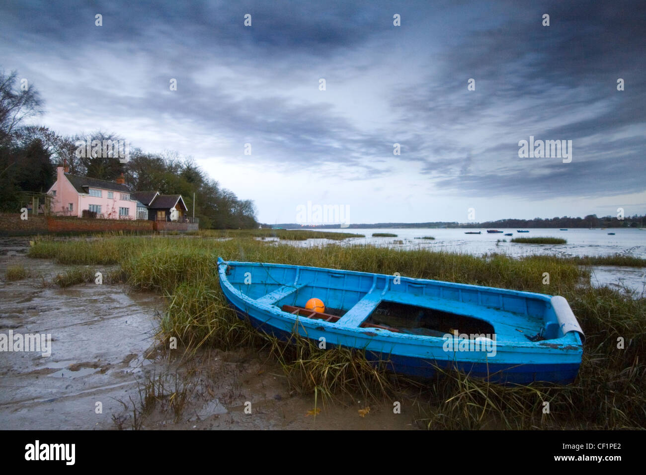 A blue rowing boat on the mud at Pin Mill. Pin Mill had links to smugglers in the 19th century and it was the setting for Arthur Stock Photo