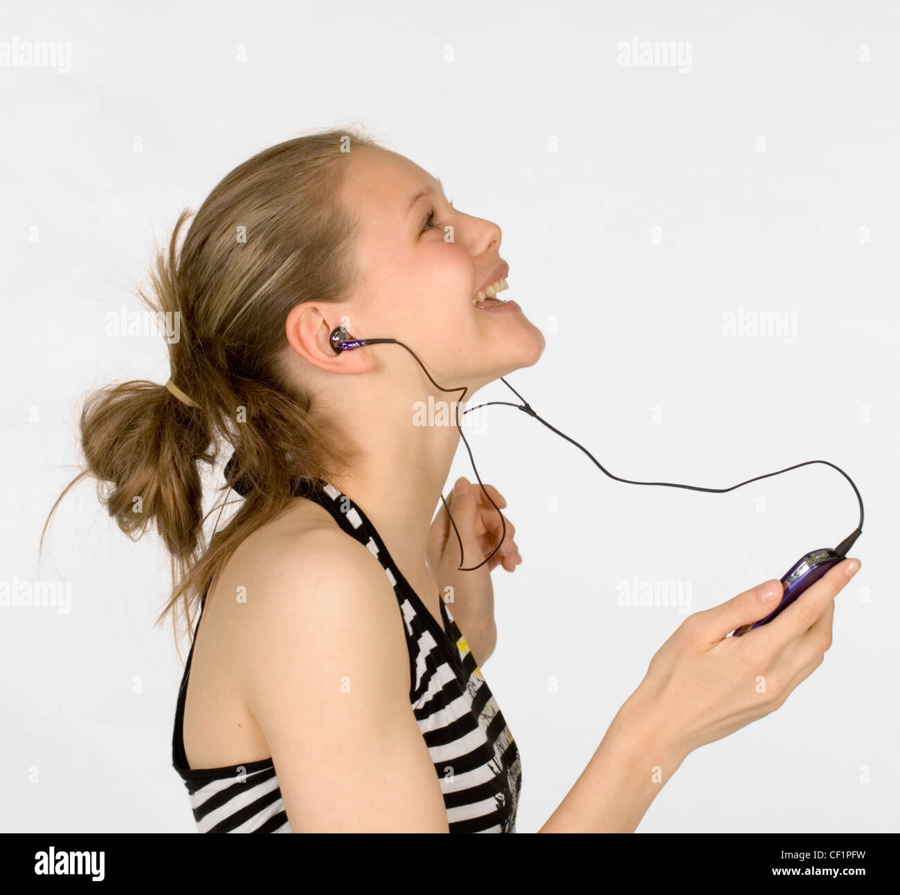 Teenager listening to music. Portable audio devices have revolutionised the way people buy and listen to music. Stock Photo