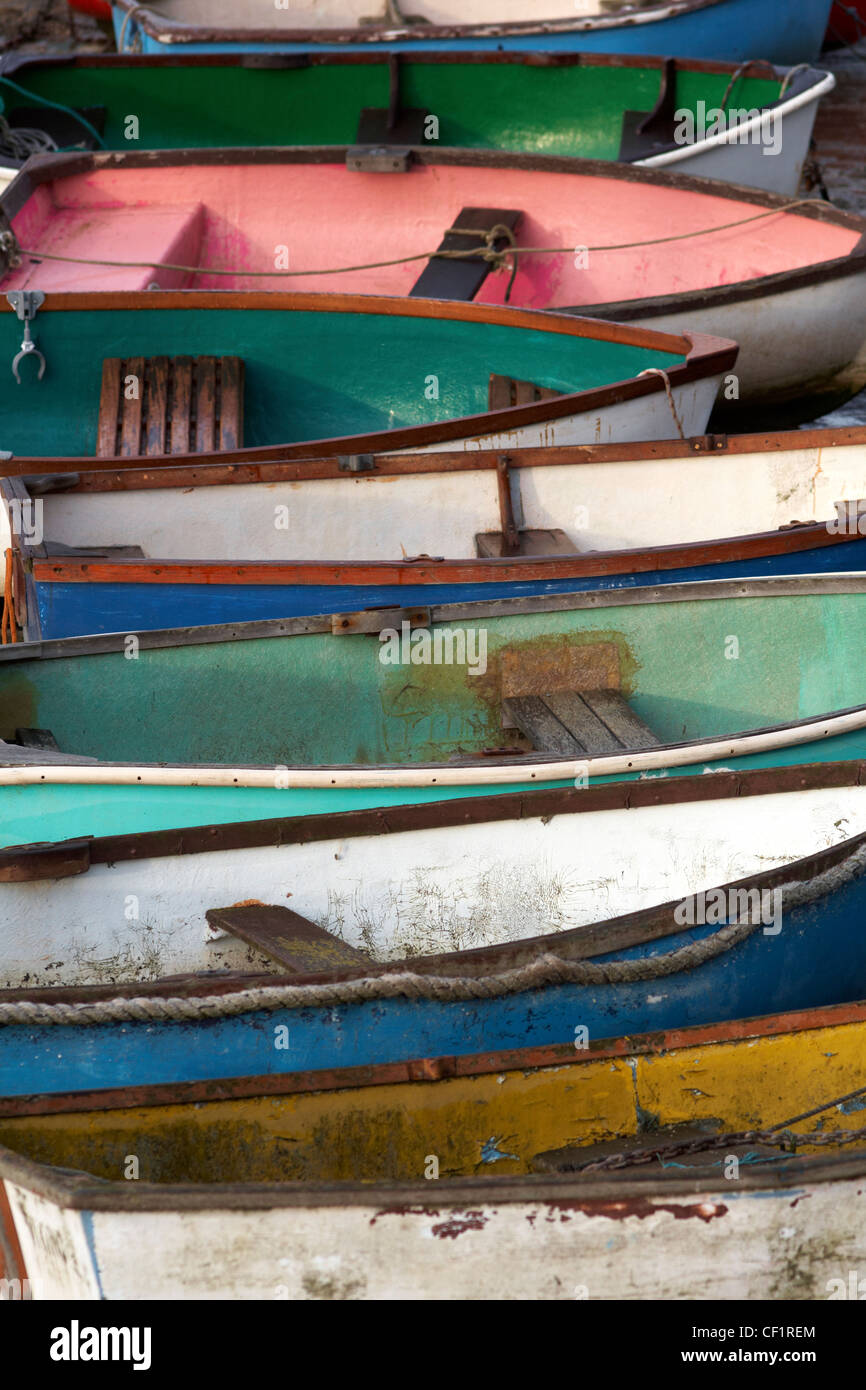 A row of colourful rowing boats near the river at Leigh-on-Sea. Stock Photo