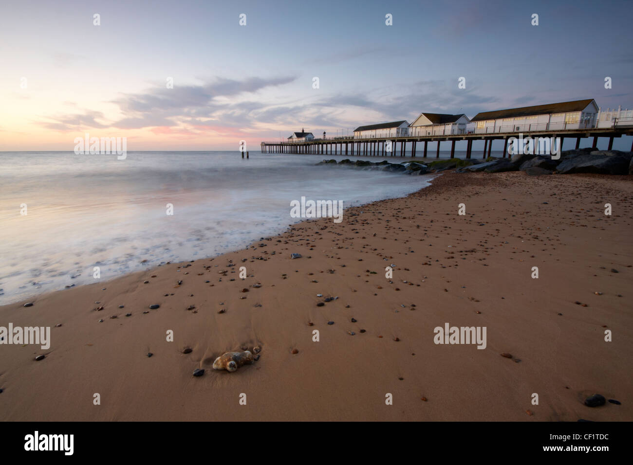 The tide flowing onto the beach by Southwold pier before sunrise. Stock Photo