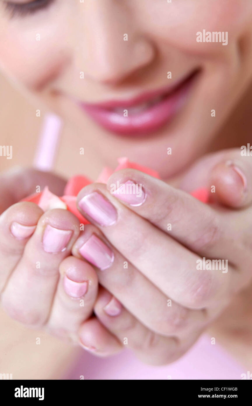 Female pink lipstick and pink nail polish wearing pink vest top leaning down to smell pink rose petals in cupped hands smiling Stock Photo - Alamy Female pink lipstick and pink nail polish wearing pink vest top leaning down to smell pink rose petals in cupped hands smiling Stock Photo - Alamy