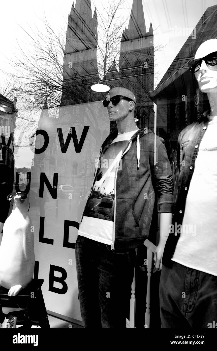 Refection of newly restored Truro Cathedral in River Island Shop window, with a  'WOW' sign and mannequins wearing sunglasses Stock Photo