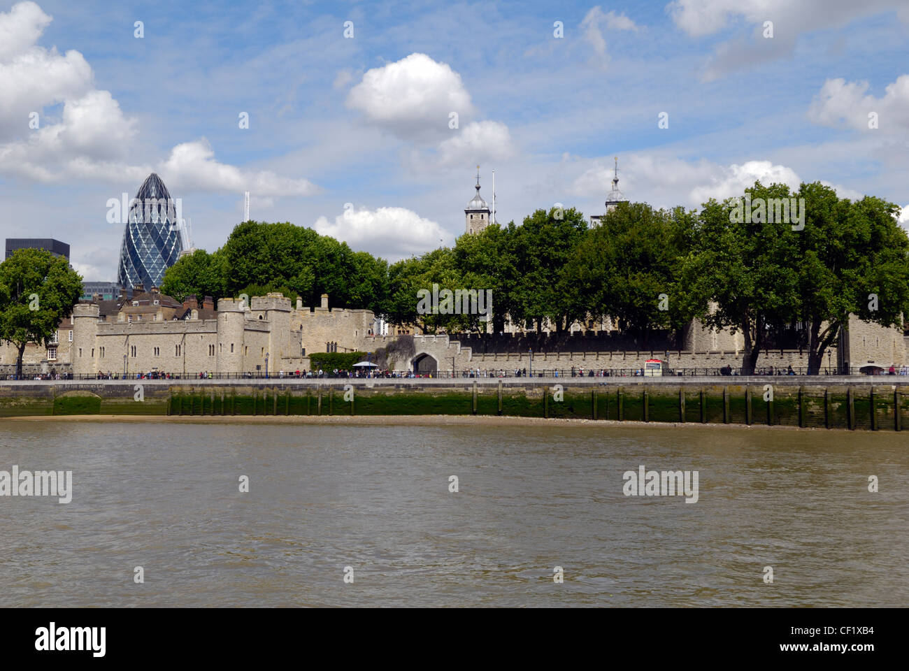 Two of London's iconic landmarks new and old. The Swiss Re Tower (Gherkin) and the Tower of London viewed from a boat on the riv Stock Photo