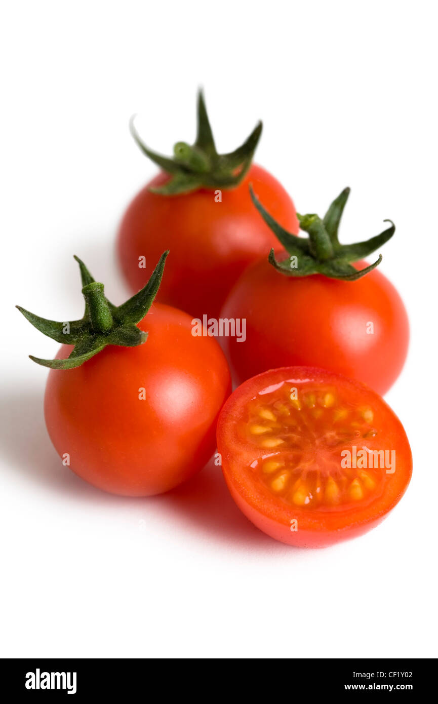 cherry tomatoes isolated with one tomato cut in half Stock Photo