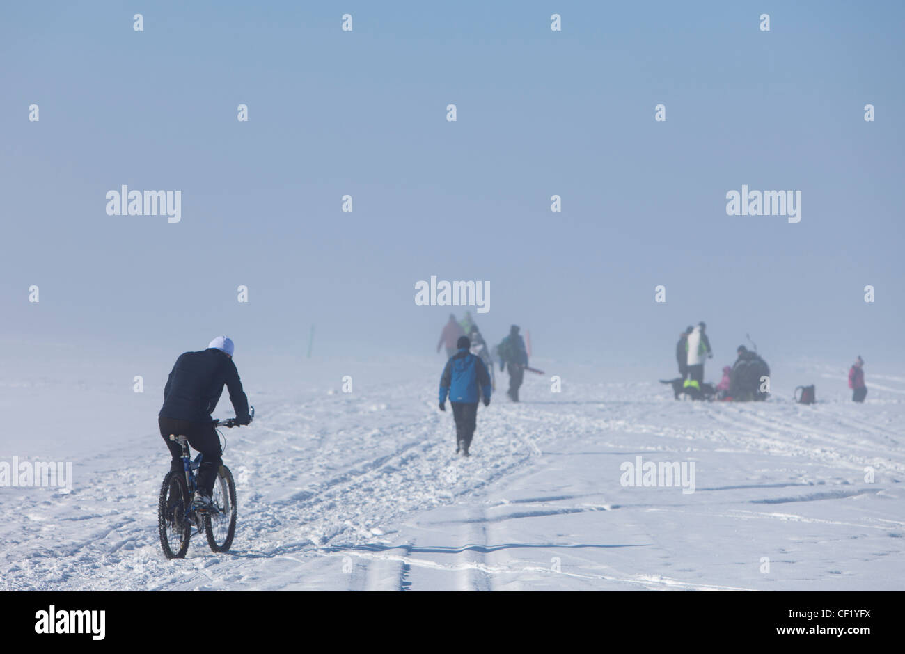 Group of people ice fishing , biking and walking on foggy sea ice at Winter , Finland Stock Photo