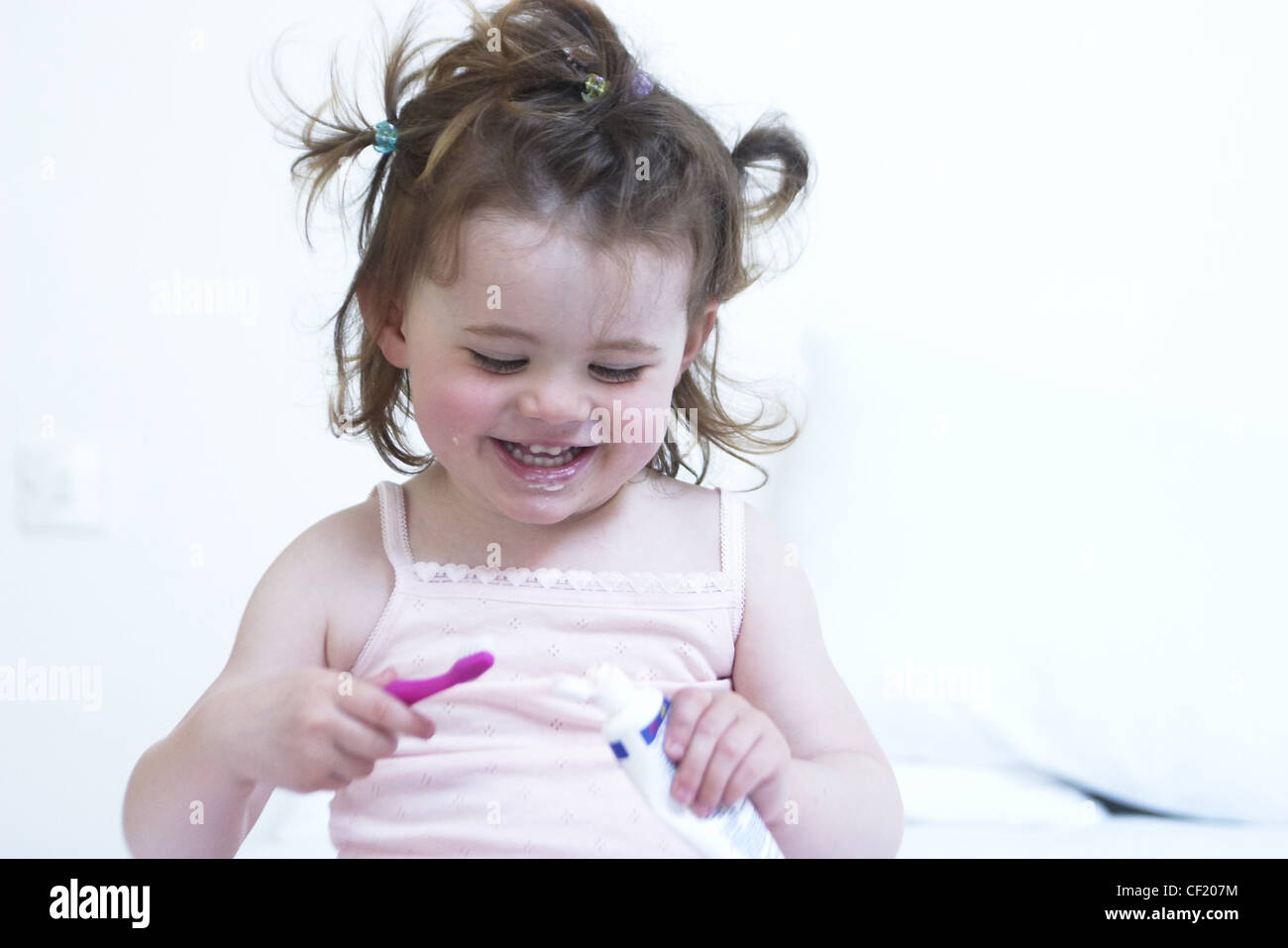 Female Child Brunette Hair Tied Up In Mini Bunches Wearing Pink