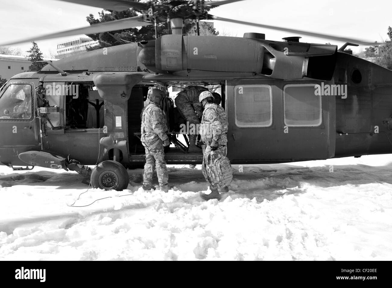 A UH-60 Black Hawk crew member assigned to A Company, 3-82 Aviation Task Force Talon at Bagram Army Air Field, helps service members unload baggage after landing in Kabul, Afghanistan, Feb. 25, 2012. The unit conducts battlefield circulation missions for Combined Joint Task Force-1, Task Force Poseidon, and Task Force Talon. The UH-60 Black Hawk has been in use since the late 1970s and continues to be one of the militaryâ€™s most versatile and reliable utility tactical transport helicopter. Stock Photo