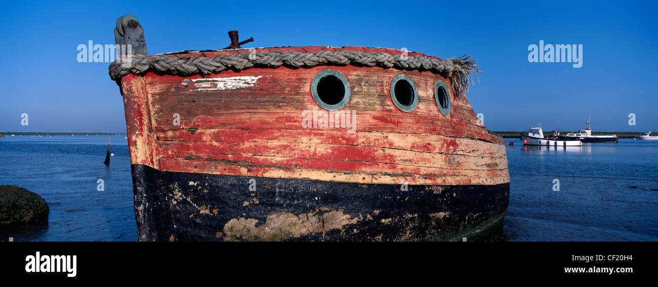 An old weathered boat on the shore of the River Ore at Orford. Stock Photo