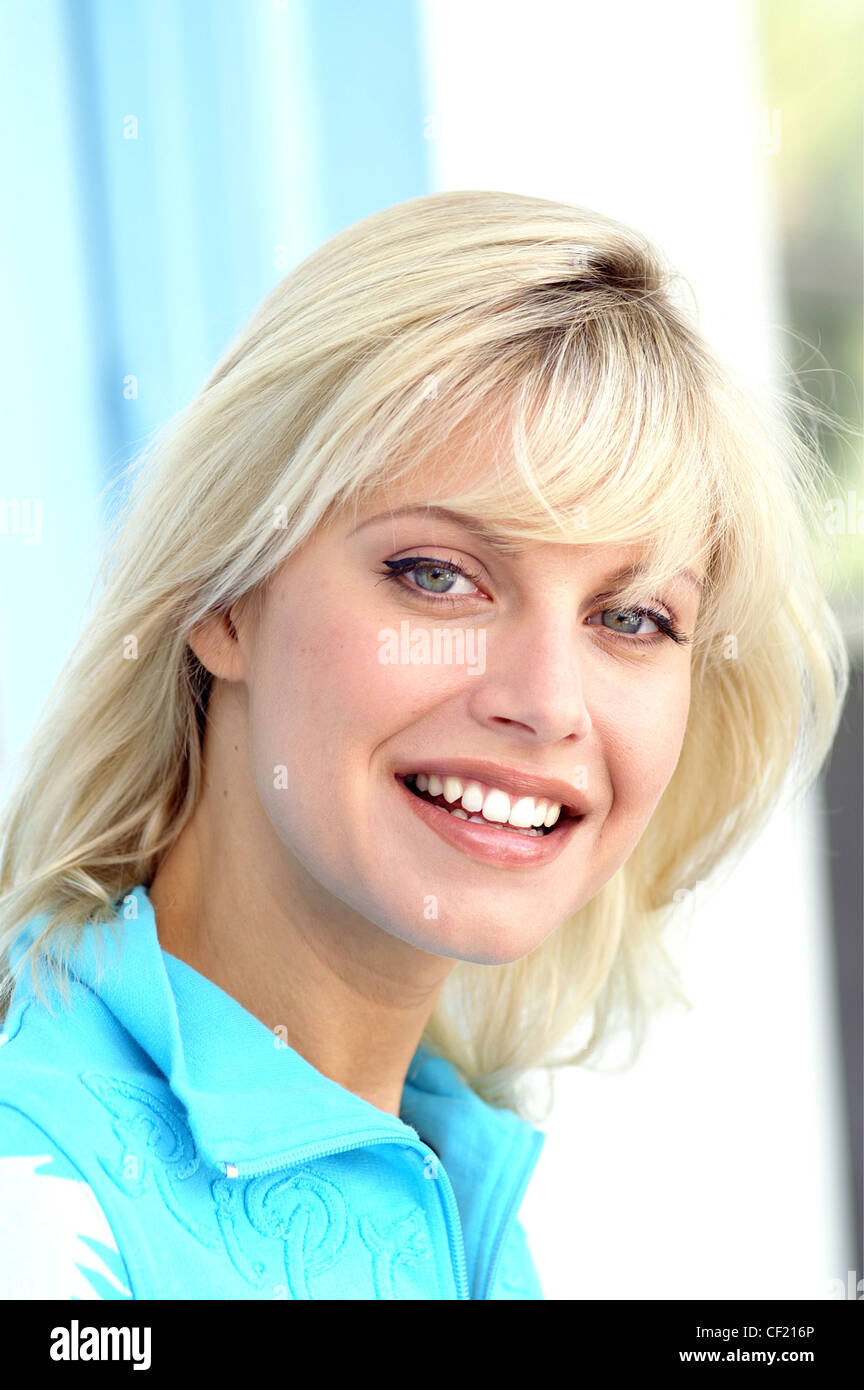 Female With Long Blonde Hair And Fringe Wearing Blue Top With Zip