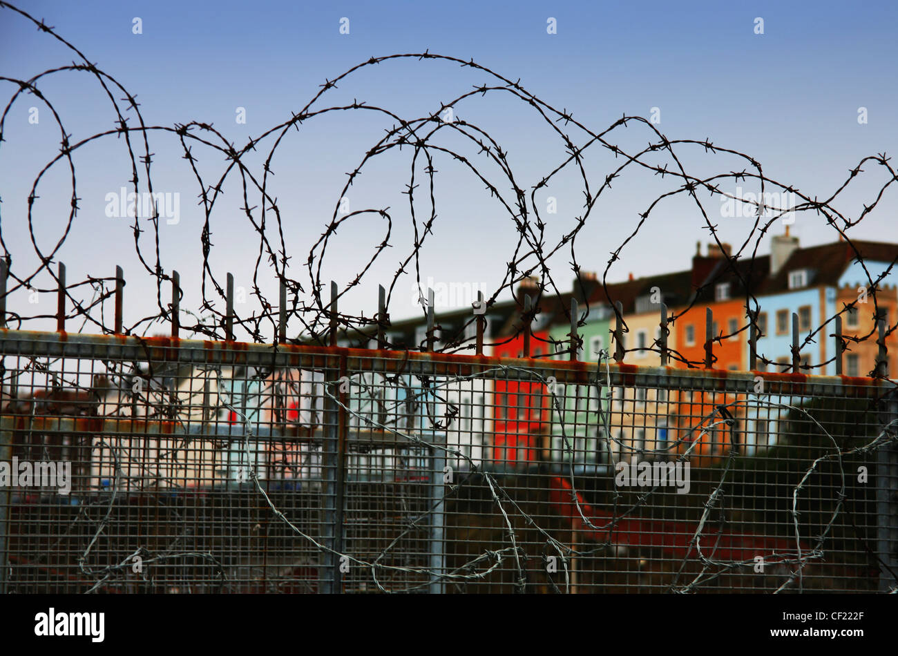 Row Houses Seen From Behind A Barbed Wire Fence; Bristol England Stock Photo