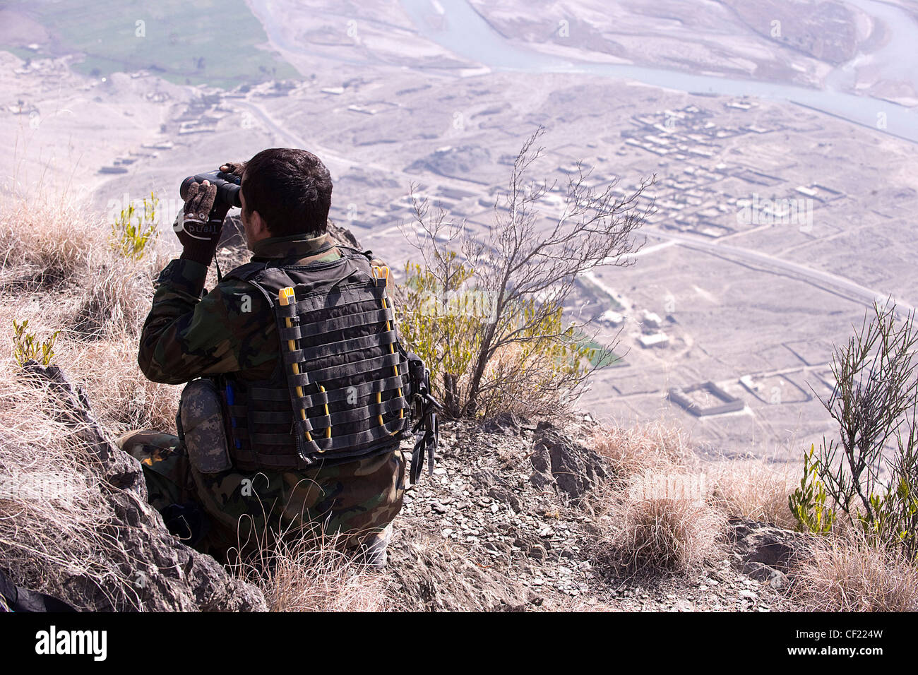 An Afghan National Army Commando scans the village below during a mission in Kunar province, Afghanistan, Feb. 25. The commando-led mission conducted reconnaissance for a future Village Stability Platform, a site Afghan forces and coalition Special Operations Forces will use to live and work with villagers Stock Photo