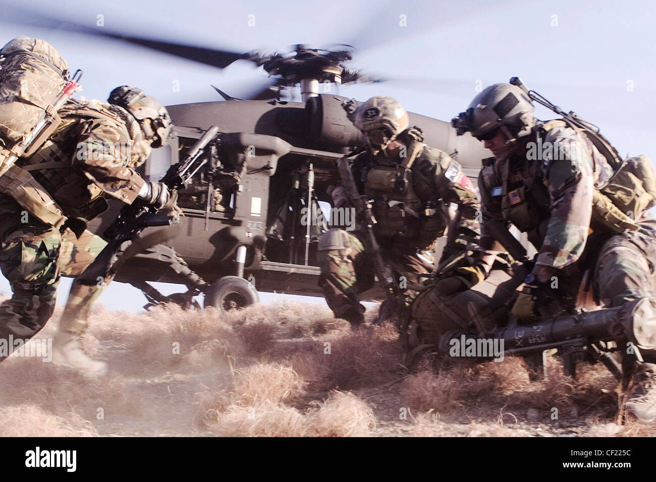 Coalition Special Operations Forces members sprint to board a UH-60 Blackhawk helicopter during a mission in Kunar province, Afghanistan, Feb. 25. The commando-led mission conducted reconnaissance for a future Village Stability Platform, a site Afghan forces and coalition SOF will use to live and work with villagers. Stock Photo