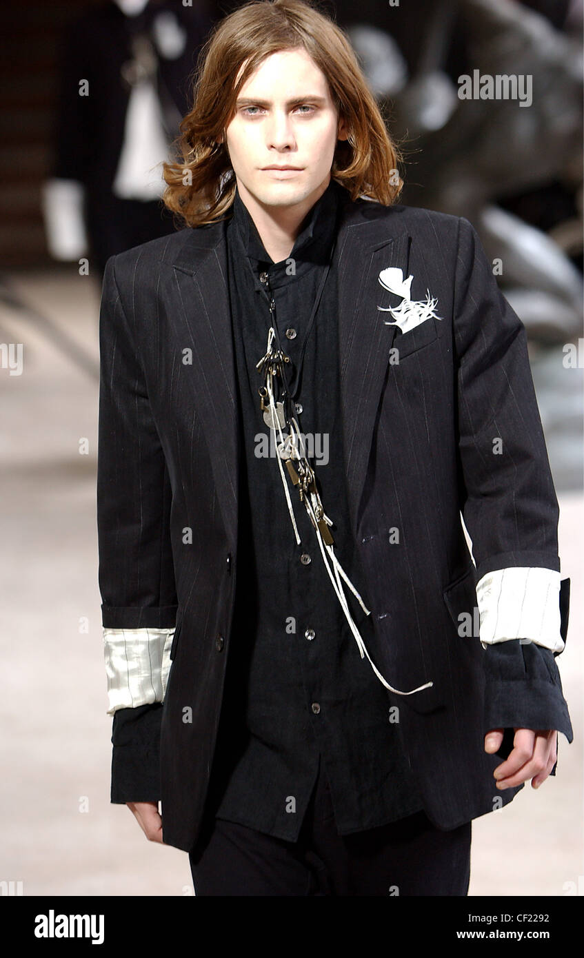 Ann Demeulemeester Paris Menswear S S Male model wearing black pinstriped  suit, accessorized padlock and keys and white Stock Photo - Alamy