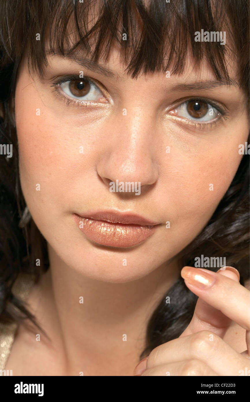 Close Up Face Of Brunette Female Fringed Hair Matching Metallic Gold