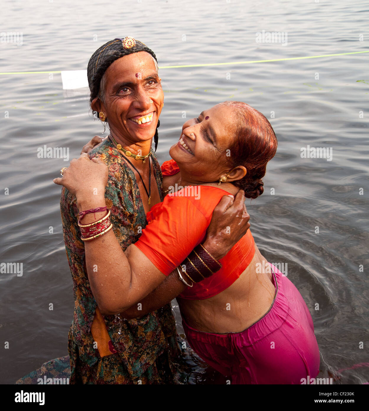 Two women bathing in Ganges River, India Stock Photo
