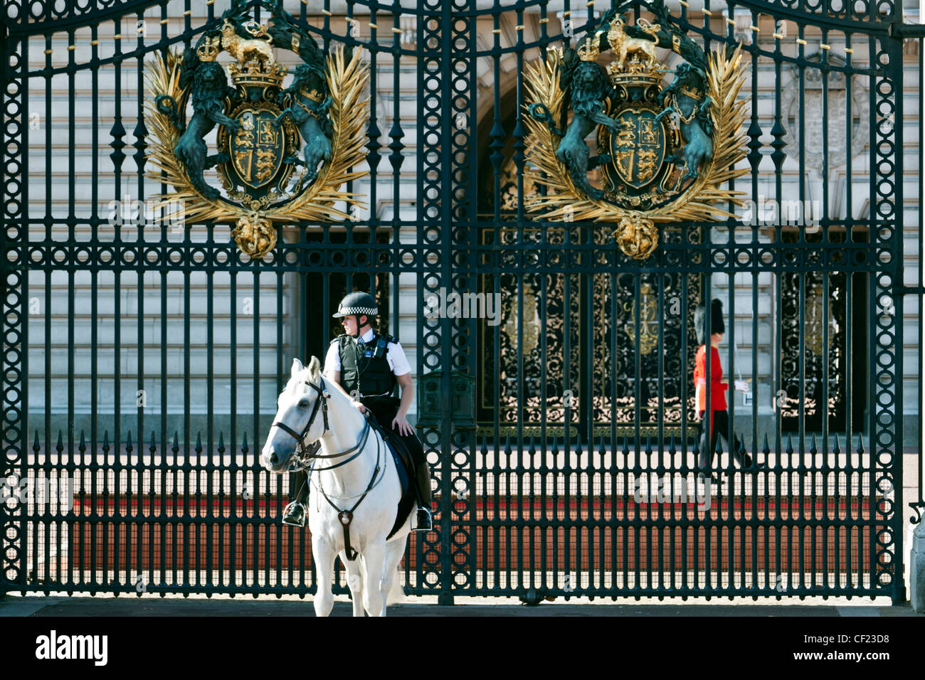 A mounted police officer and a Queen's Guard on duty outside Buckingham Palace Stock Photo Alamy