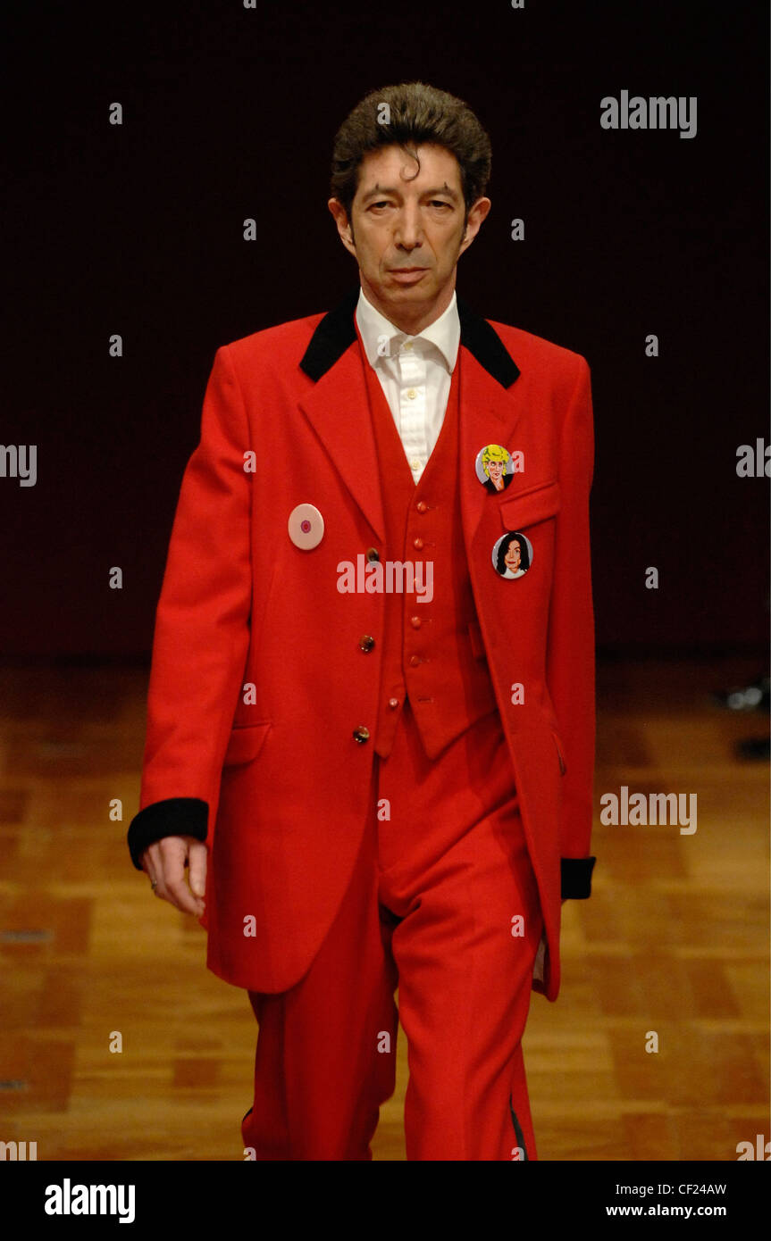Comme des Garcon Menswear Paris Ready to Wear British artist Dougie Fields bouffant and ringlet on forehead wearing red suit Stock Photo