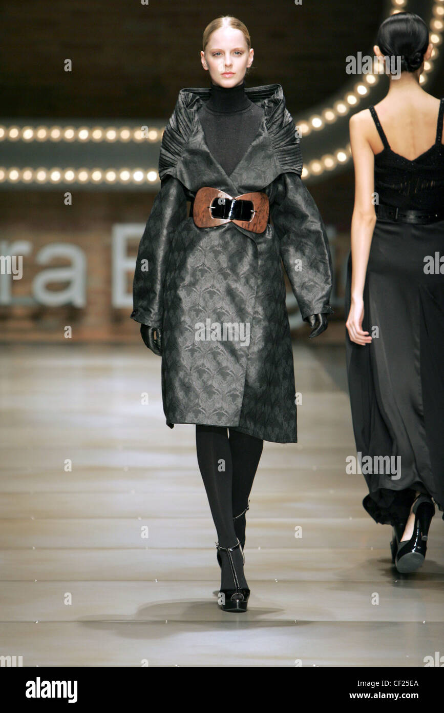 Laura Biagiotti Milan Fashion Week Autumn Winter Model wearing black polo neck knitted jumper, black satin embossed print coat Stock Photo