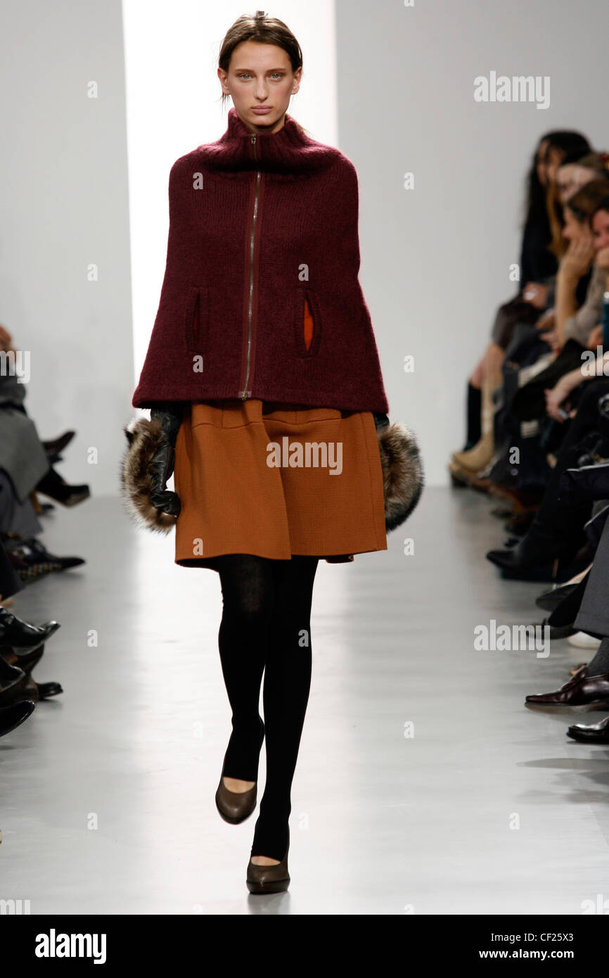 Marni Milan Ready to Wear Autumn Winter Burgundy zip up cape jacket over  sack dress, black footless tights, leather and fur Stock Photo - Alamy