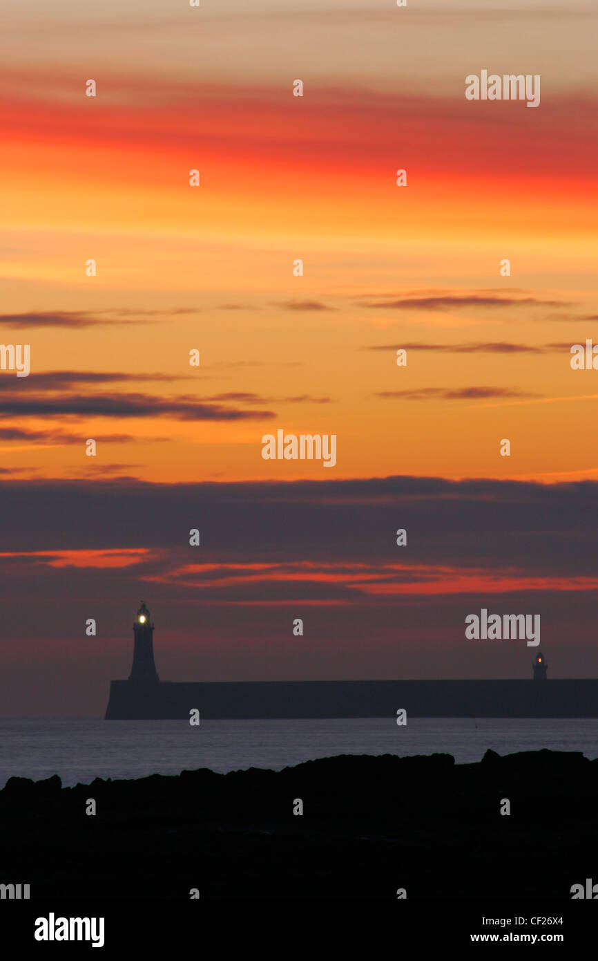 Sunrise looking towards the North Tyne Pier and lighthouse in Tynemouth. Stock Photo