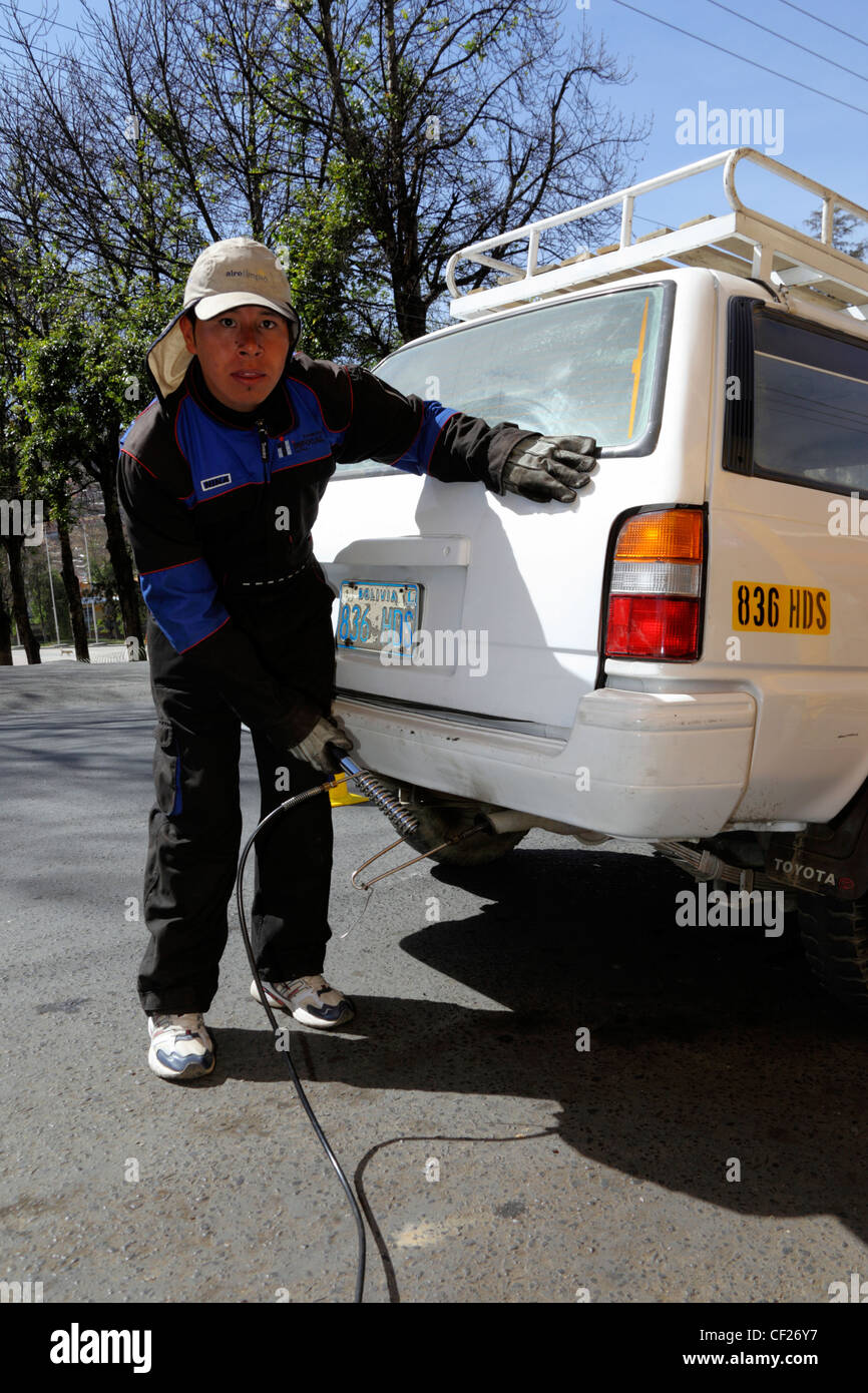 A mechanic tests exhaust emissions from a white Toyota SUV car during Clean Air Week (a campaign to reduce air pollution), La Paz, Bolivia Stock Photo
