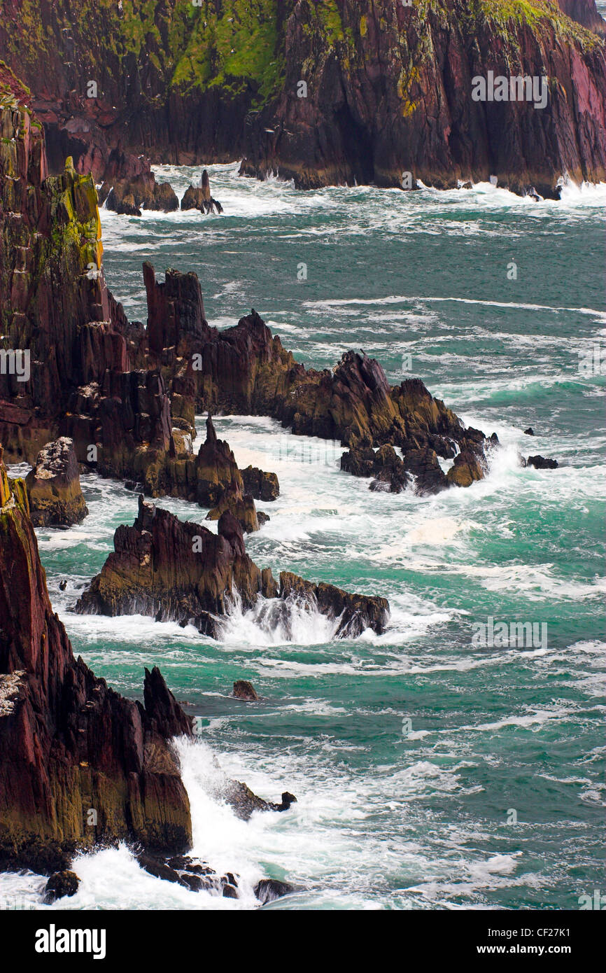 Waves crash against the sheer cliffs of Dingle Bay. Stock Photo