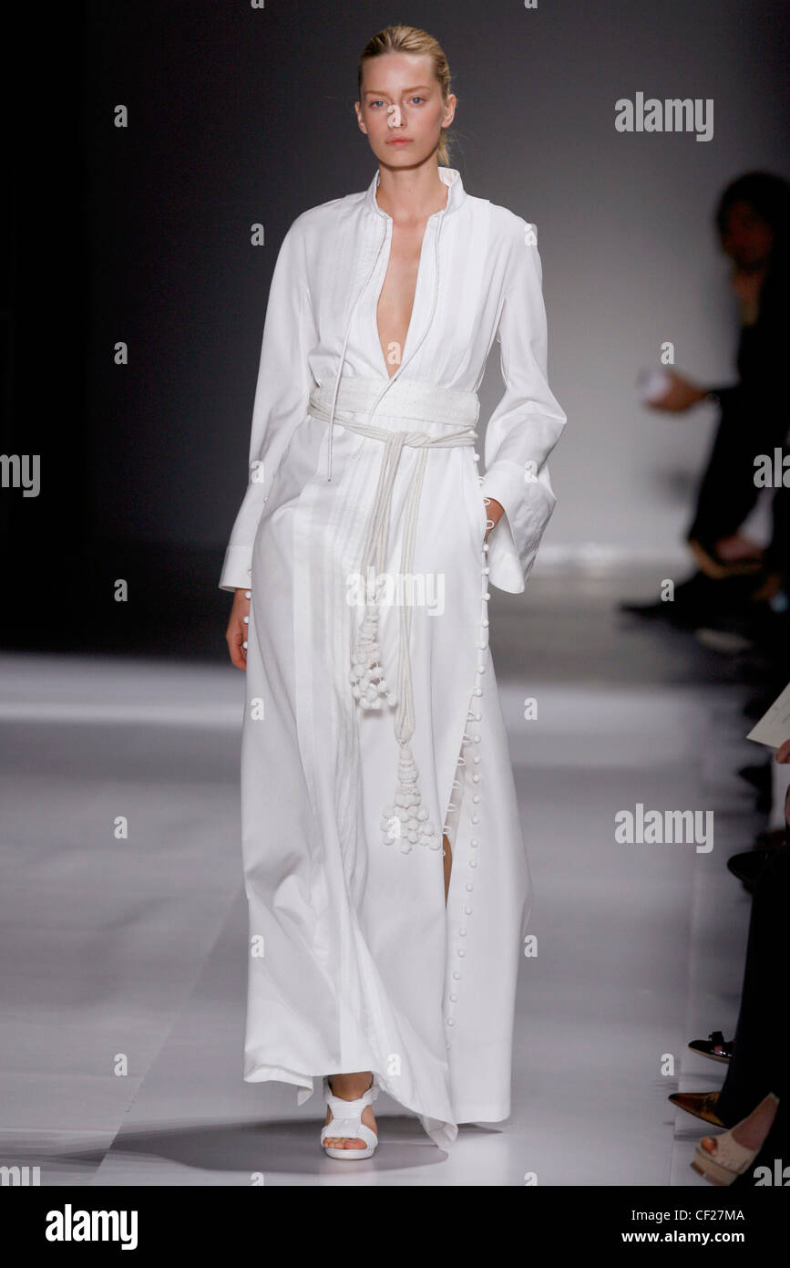 Loewe Paris Ready to Wear Spring Summer All white long Kaftan dress accessorized with fringed tie belt and sandals Stock Photo